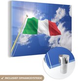 MuchoWow® Glasschilderij 90x60 cm - Schilderij acrylglas - De vlag van Italië wappert in de lucht - Foto op glas - Schilderijen
