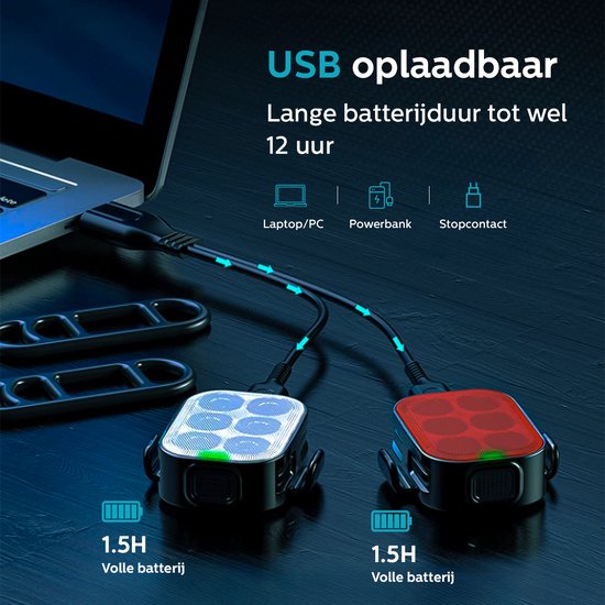 Lampes de vélo blanches et rouges chargées via des câbles USB connectés à un ordinateur portable.