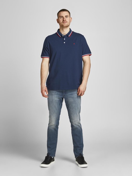 Donkerblauw poloshirt met rode en witte strepen op de kraag en mouwen. Rode merklogo op de borst.