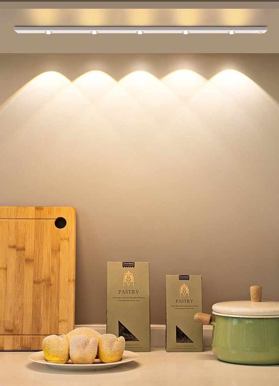 Zwarte LED-strip met vier spots boven een keukenblad met snijplank, brood en een pan.