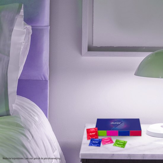 Een Durex doos met vier individueel verpakte condooms in rood, blauw, roze en groen op een nachtkastje.