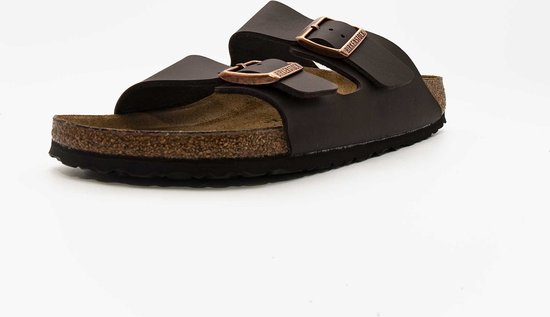 Bruine Birkenstock Arizona slipper met koperkleurige gespen en kurken voetbed.