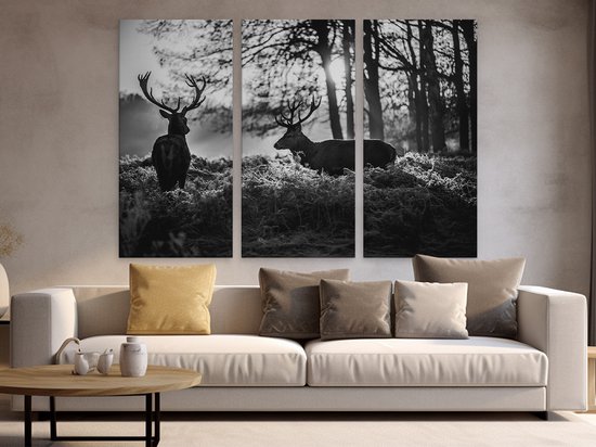 Peinture triptyque avec deux cerfs dans un environnement boisé, accrochée au-dessus d'un canapé.