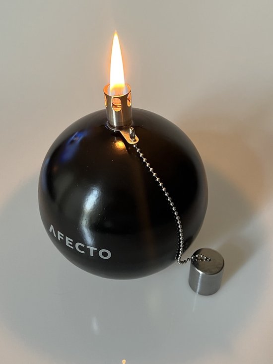 Zwarte, bolvormige olielamp van Afecto met Afecto logo. Met brandende lont en metalen dop aan ketting.