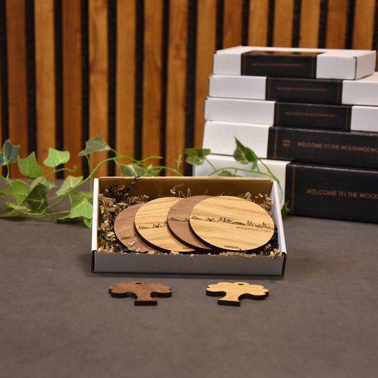 Sous-verres en bois avec la silhouette d'Eemnes, deux en bambou avec la ville, deux en bois sombre. Présentés dans une boîte cadeau avec matériel de remplissage.