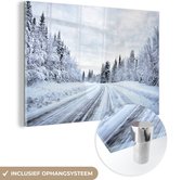 MuchoWow® Glasschilderij 180x120 cm - Schilderij acrylglas - Een besneeuwde weg wat omringt is door een winterlandschap - Foto op glas - Schilderijen