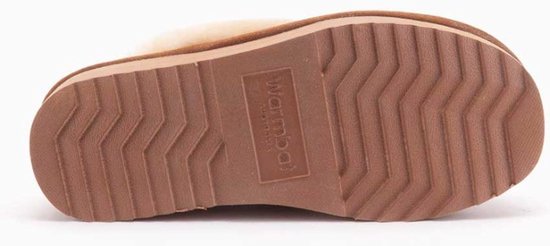 Onderkant van een cognac suède slipper met een beige geribbelde rubberen zool met Warmbat logo.