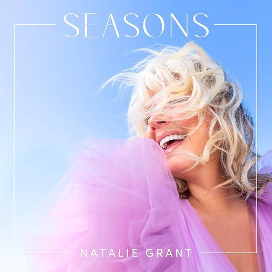 Natalie Grant - SEASONS albumcover met een lachende vrouw met wapperend blond haar en een paarse tule jurk.