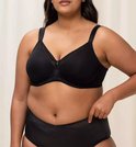Zwarte beha met mesh-inzetstukken op de cups, gedragen door een model met een volle figuur.