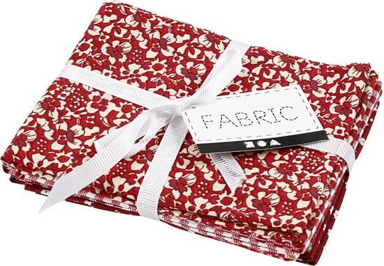Stapel rode stoffen met bloemenprint, samengebonden met wit lint en een label 'FABRIC'.