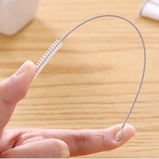 Hand die een flexibele rietjesborstel vasthoudt, met een metalen spiraal en witte borstelharen.