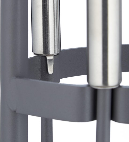 Detail van de zilverkleurige, cilindrische handvatten van de grijze haardset.