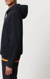 Donkerblauwe Napapijri hoodie voor heren, gedragen met een oranje shirt eronder.