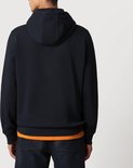 Man, achterkant donkerblauwe Napapijri hoodie, met oranje T-shirt eronder.