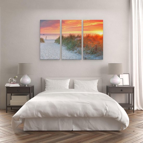 Toile triptyque d'un chemin de sable à travers les dunes vers la mer, coucher de soleil avec ciel orange.