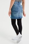 Meisje in een spijkerrok met zwarte legging.