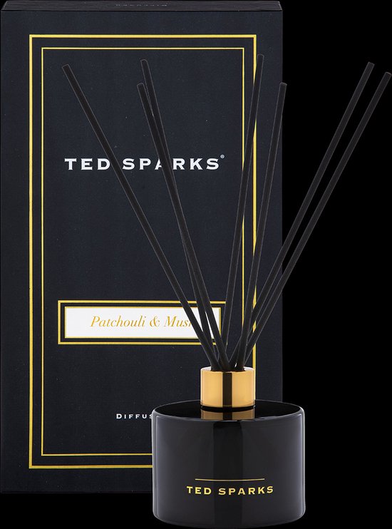 Zwarte glazen diffuser van Ted Sparks met gouden dop en zwarte stokjes, naast de verpakking.