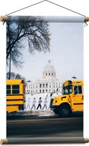 WallClassics - Textielposter - Gele Schoolbussen bij Gebouw - 40x60 cm Foto op Textiel