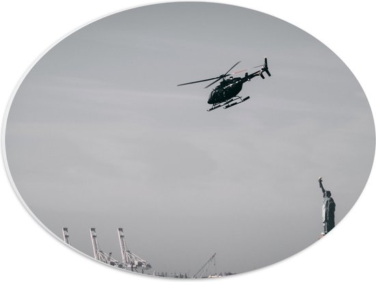 WallClassics - PVC Schuimplaat Ovaal - Helikopter zwevend boven Vrijheidsbeeld in New York - 40x30 cm Foto op Ovaal  (Met Ophangsysteem)