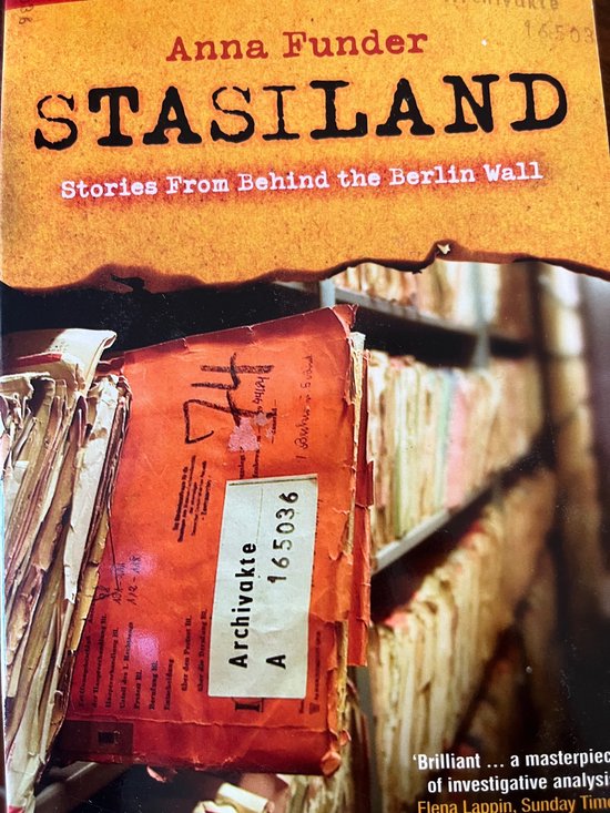 Boekomslag 'Stasiland' van Anna Funder met een oranje-rood archiefdossier, nummer 165036, tegen een achtergrond van archieven.