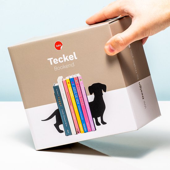 Hand die de verpakking van de 'Teckel Bookend' oppakt, met afbeelding van de boekensteun.