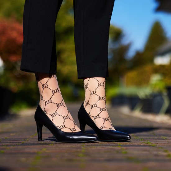 Transparante Bonnie Doon panty met ruitjespatroon, gedragen met zwarte pumps.