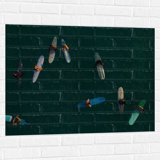 WallClassics - Muursticker - Bovenaanzicht van Groep Surfers op Oceaan - 100x75 cm Foto op Muursticker