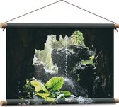 WallClassics - Textielposter - Groen Plantje Achter Stromend Water in een Grot - 60x40 cm Foto op Textiel