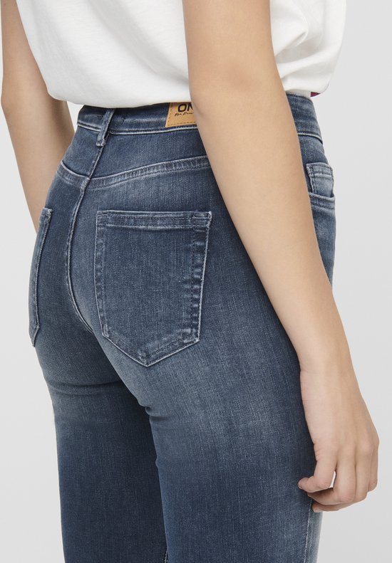 Detail van de achterkant van een vrouw in een donkerblauwe skinny jeans.