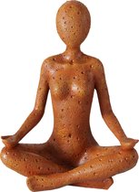 Beeld van een vrouw in yoga kleermakerszit