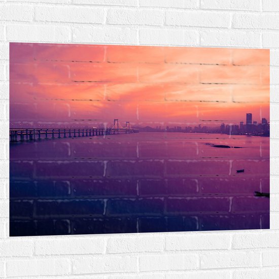 WallClassics - Muursticker - Hele Lange Brug over het Water naar de Stad - 100x75 cm Foto op Muursticker