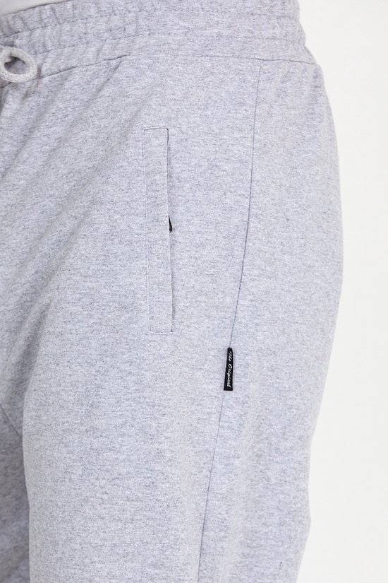 Detail van een lichtgrijze joggingbroek met een zijvak en een label met de tekst 'Originals'.