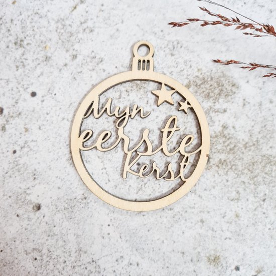 Houten kerstbal met de tekst 'Mijn eerste kerst' en sterren.