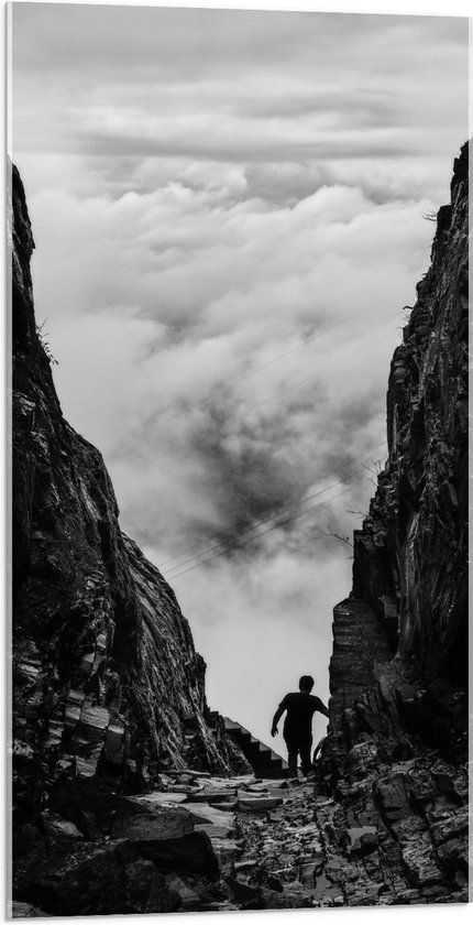 WallClassics - Acrylglas - Man tussen Rotsen boven Wolken in Zwart-wit - 50x100 cm Foto op Acrylglas (Met Ophangsysteem)