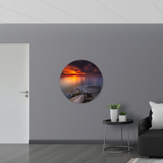 WallClassics - Muursticker Cirkel - Kleine Rotsen aan het Water met Zonsondergang - 90x90 cm Foto op Muursticker
