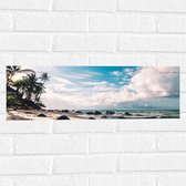 WallClassics - Muursticker - Strand met Grote Keien aan de Zee - 60x20 cm Foto op Muursticker