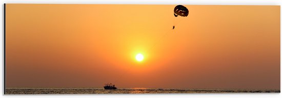 WallClassics - Dibond - Parasailen bij Zonsondergang Boven de Zee - 60x20 cm Foto op Aluminium (Met Ophangsysteem)