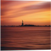 WallClassics - Vlag - Oranje Lucht boven Vrijheidsbeeld in New York - 50x50 cm Foto op Polyester Vlag