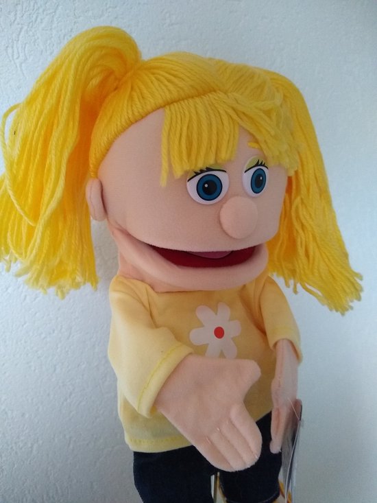 Handpop met blonde staartjes, blauwe ogen, gele trui met witte bloem en spijkerbroek.