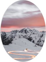 PVC Schuimplaat Ovaal - Verlichte Weg door Sneeuw Landschap en Bergen tegen de Avond - 60x80 cm Foto op Ovaal (Met Ophangsysteem)