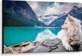 WallClassics - Canvas - Witte Hond liggend bij Bergen en Water - Samojeed - 120x80 cm Foto op Canvas Schilderij (Wanddecoratie op Canvas)