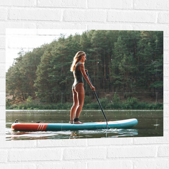 Muursticker - Blonde Vrouw op Supbord op Water langs Rij Bomen - 80x60 cm Foto op Muursticker