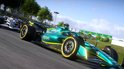 Groene F1-auto met gele accenten racet met een witte auto op een circuit.