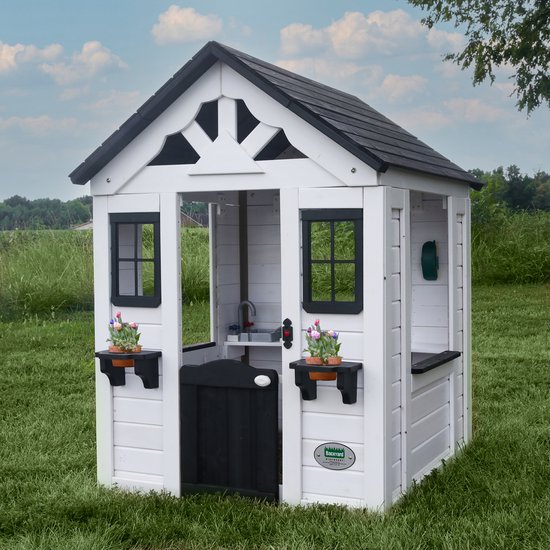 Wit houten speelhuis met zwart dak, zwarte deur, ramen, bloempotten en een groene telefoonhouder.