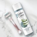 Scheergel bus, scheermesje en een Venus scheermesje liggen op een marmeren achtergrond. Tekst op de bus: '200ml', 'Satin Care SENSITIVE', 'ALOE VERA GLIDE'.