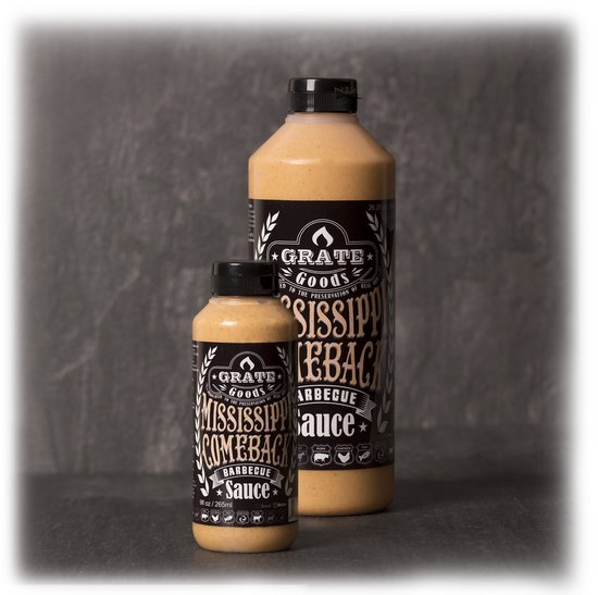 Twee flessen Grate Goods Mississippi Comeback Barbecue Saus in verschillende formaten op een donkere achtergrond.