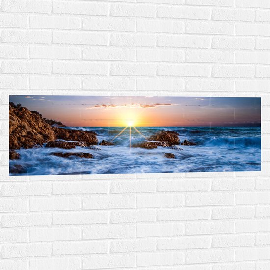 WallClassics - Muursticker - Felkleurige Zonsondergang achter Wilde Zee - 120x40 cm Foto op Muursticker