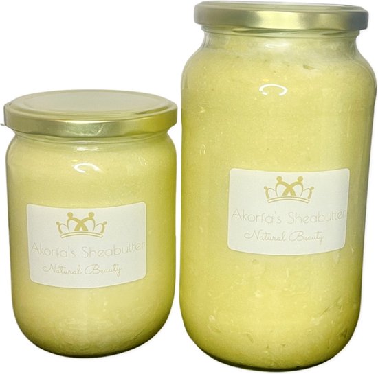 Twee glazen potten met gouden deksels, gevuld met romige gele sheaboter. Een kleiner en een grotere pot, beide met een label 'Akorfa's Shea Butter Natural Beauty'.