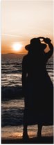 Poster Glanzend – Vrouw kijkend naar de Zee en Zonsondergang - 30x90 cm Foto op Posterpapier met Glanzende Afwerking