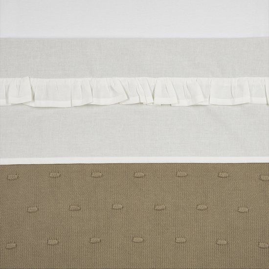 Witte stof met ruches, onderkant is bruine gebreide stof met stiksels.